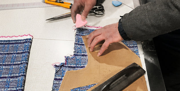 Hands mark a cut with chalk against the pattern card