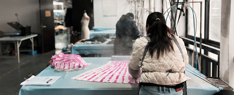 Steam rises from the pressing tables on the finishing floor